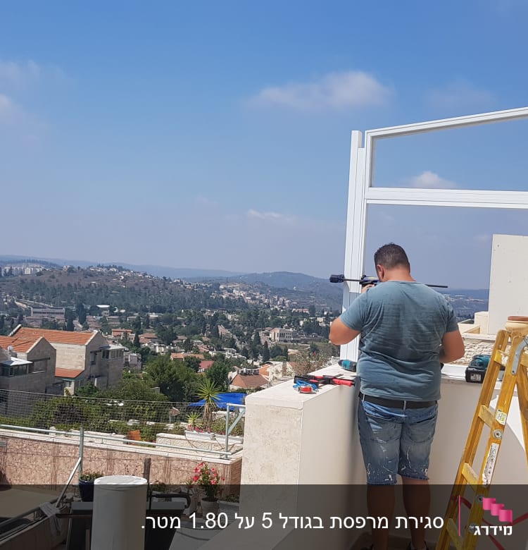 אדם עובד עם מסגרת אלומיניום על מרפסת